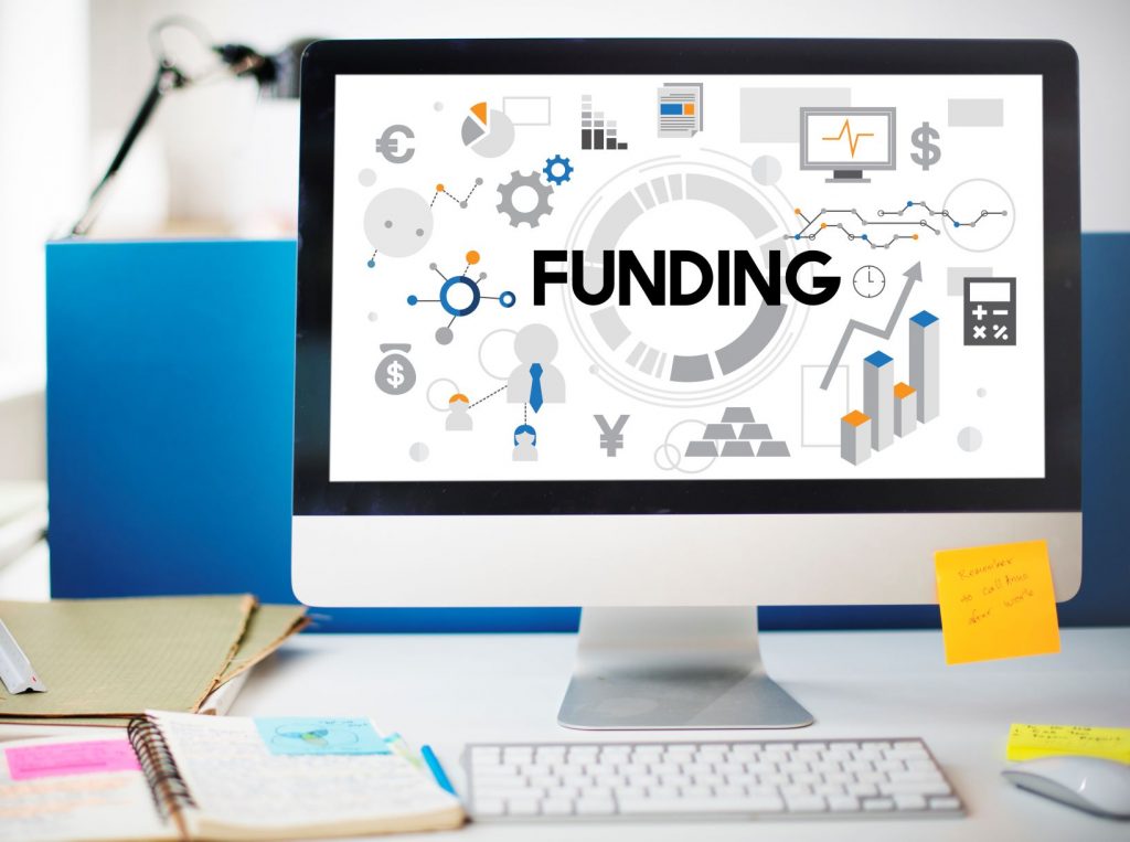 Stock image of a computer with an image that spells out the word funding on screen