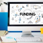 Stock image of a computer with an image that spells out the word funding on screen