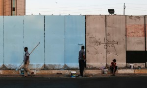 Workers paint blast walls in Baghdad. Photograph: Sam Tarling