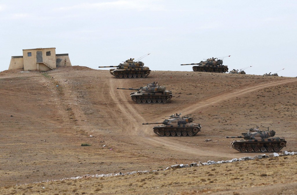 Turkish army tanks take up position on the Turkish-Syrian border near the southeastern town of Suruc in Sanliurfa province September 29, 2014. Turkish tanks and armoured vehicles took up positions on hills overlooking the besieged Syrian border town of Kobani on Monday as shelling by Islamic State insurgents intensified and stray fire hit Turkish soil, a Reuters correspondent said. At least 30 tanks and armoured vehicles, some with their guns pointed towards Syrian territory, were positioned near a Turkish military base just northwest of Kobani. Plumes of smoke rose up as shells hit the eastern and western sides of Kobani and sporadic bursts of machinegun fire rang out. REUTERS/Murad Sezer (TURKEY - Tags: POLITICS CONFLICT MILITARY TPX IMAGES OF THE DAY)