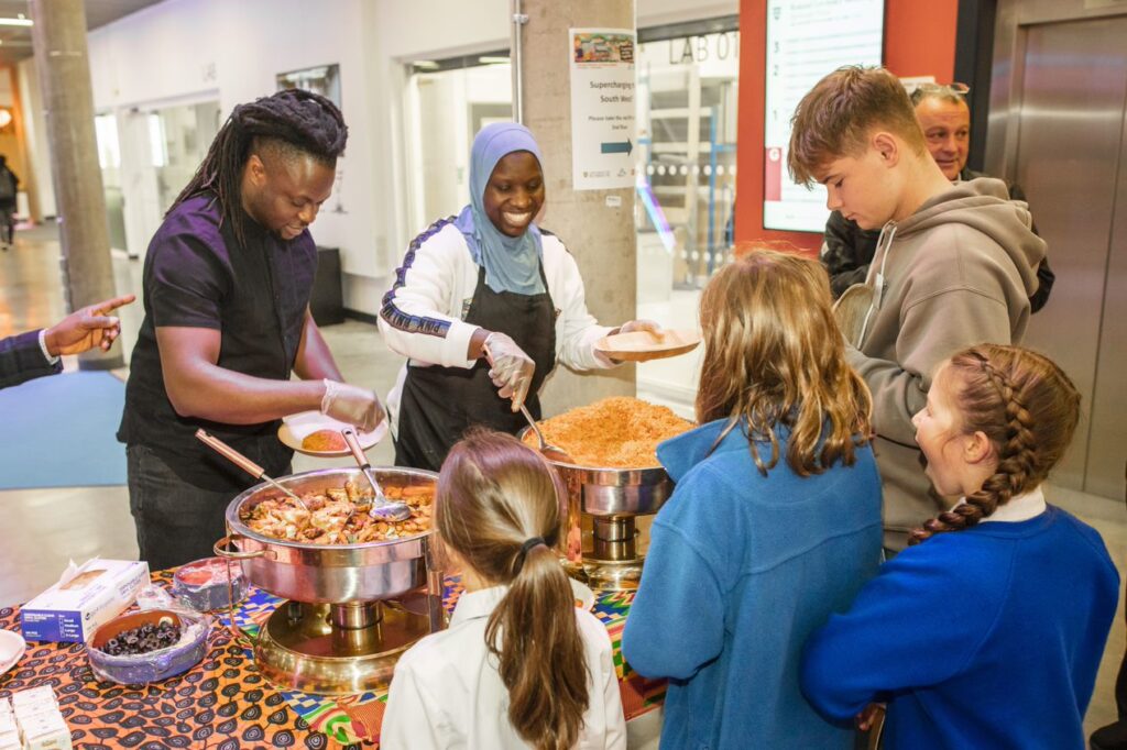 Jollof Kitchen serving food to school children at the From Field To Plate event, at Crosspoint in the Roland Levinksy building, at the University of Plymouth.