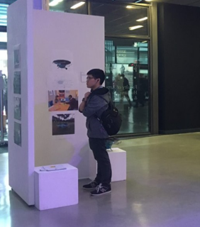 A person looking at the exhibition work displayed at Crosspoint, in the Roland Levinksy Building at the University of Plymouth.