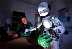 Dr Martin Peniak with a Humanoid Robot that is holding a ball